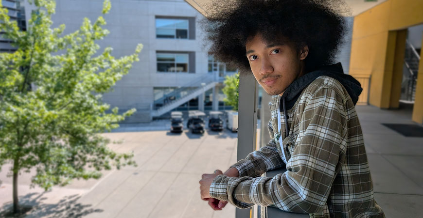 UC Merced student Tyrese Francis poses at an outdoor hallway