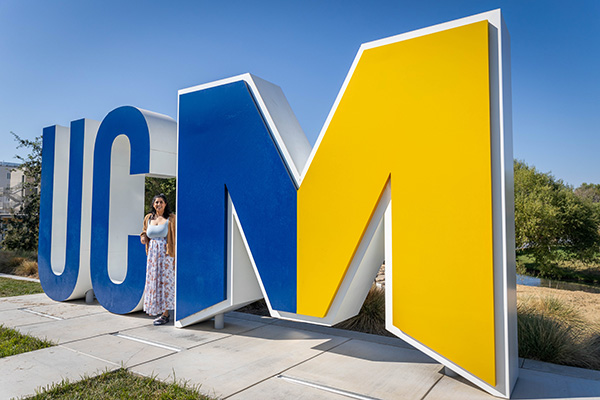 Arabi Seshappan in front of the UCM letters on campus